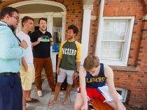 group of male students hanging out in front of a residence hall