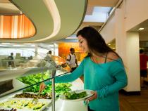 Student grabbing a salad for lunch from the salad bar