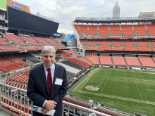 Dr. Gary Schwartz poses in front of the field at the Cleveland Browns Stadium