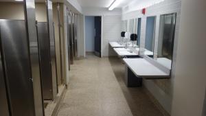 Norton, Raymond, Sherman, and Tyler House bathroom with sinks, shower stalls, and toilet stalls