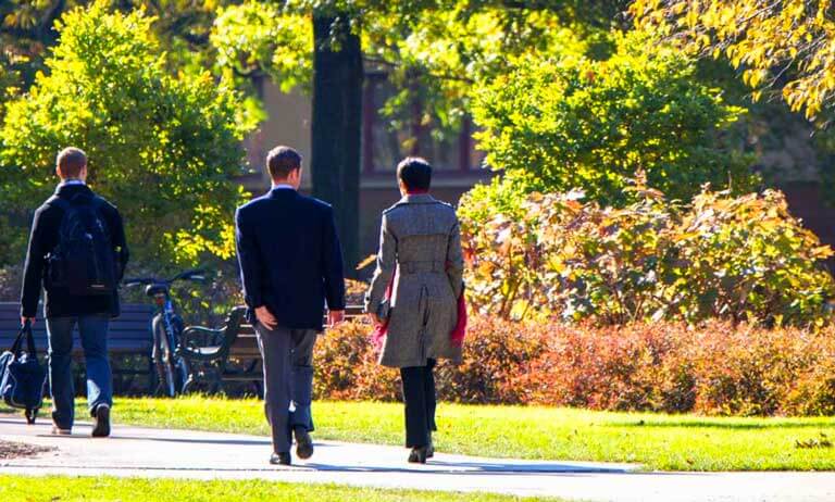 photo of case quad people walking amongst autumn trees