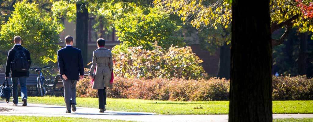 photo of case quad people walking amongst autumn trees