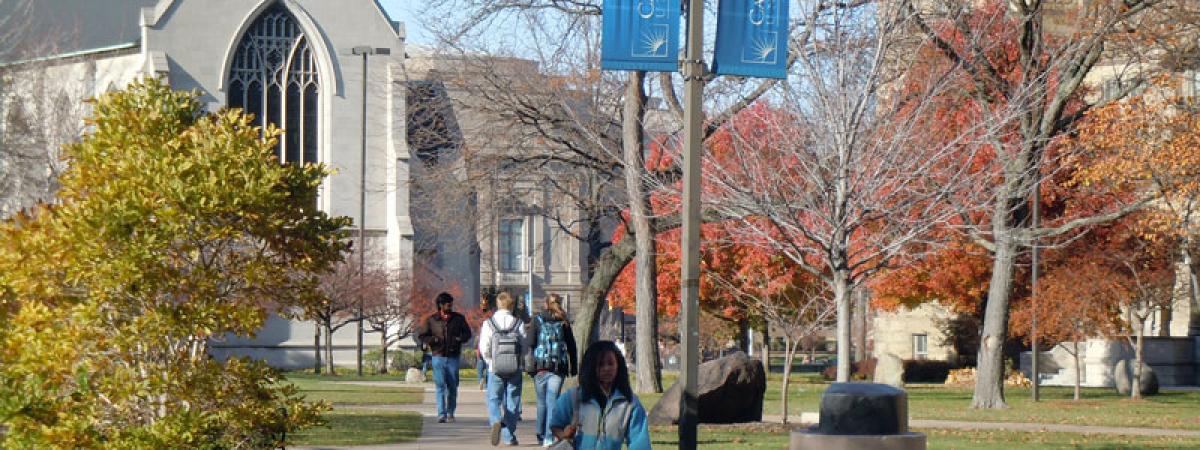 Female Case Western Reserve University student walking with three students behind her