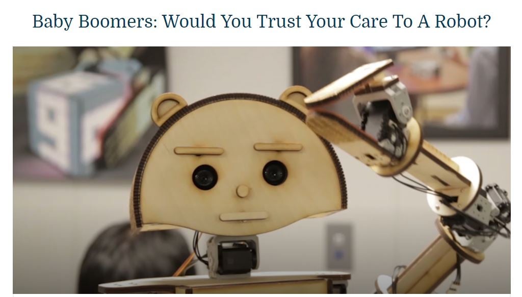 A screenshot of an ideastream® video about the Smart LIving Lab's robot companion project by Case Western Reserve University nurse researchers. The headline of the story, visible at the top of the picture, reads: "Baby Boomers: Would You Trust Your Care to a Robot?" In the photo, a plywood-based robot named Woody is shown.