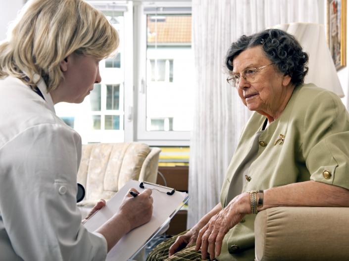Female nurse asking questions to an elderly patient.