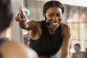 Woman cycle instructor pointing at class