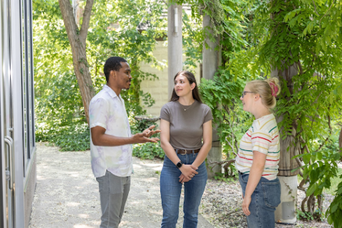 three students standing and talking