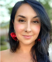 Headshot of Samantha Cocco, a white woman with dark hair and bright red earrings