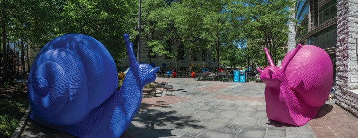 Two very large snail sculptures, one blue and one pink