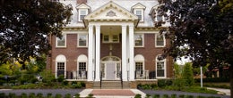 A brick house with white columns.