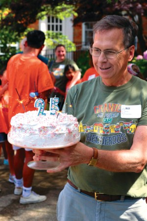 Bill Gruber holding birthday cake for camp's 25th year