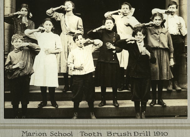 Children standing on the steps brushing their teeth