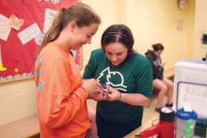 Julia Blanchette checked camper Caroline Rusinoff's blood sugar at Camp Ho Mita Koda.