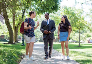 Two students talking outside with Case Western Reserve University’s new provost, Ben Vinson III.