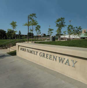 Close up of the engraved sign that reads 'Nord Family Greenway' near the eastern edge.