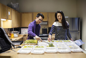 A male and female Case Western Reserve University student work together to prepare meals to distribute in Cleveland