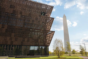 The exterior of the Smithsonian’s National Museum of African American History and Culture, with the Washington Monument in the background