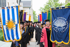 Photo of Case Western Reserve University faculty and students holding banners at graduation