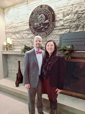 Photo of Jerod and Mylynn Tufte in front of the state seal of North Dakota