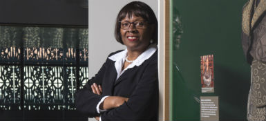 A portrait of Elaine Nichols standing near an exhibit at the Smithsonian’s National Museum of African American History and Culture