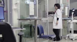 Jessica Zitter, MD, leaning against a door to a patient's room and looking in