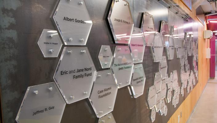 A wall in the think[box] that shows donor plaques.