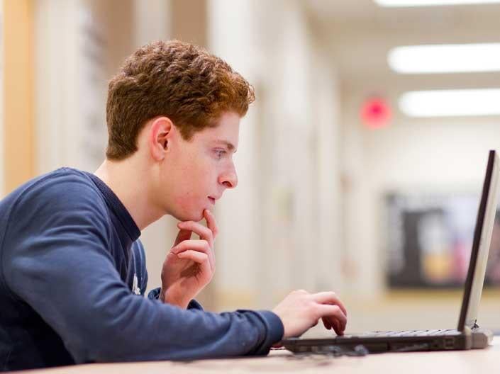 Male Case Western Reserve University student typing on a computer