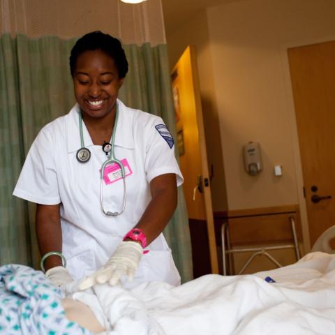 nursing student in uniform interacting with a patient