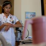 uniformed nursing student with stethoscope in hospital room