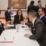 Students in business attire meeting business professionals at a table 