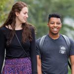 a white female student and a black male student walking