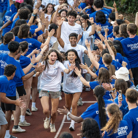 New students running through a tunnel of current students