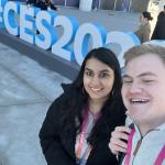 A male and female posing for a selfie in front of a CES sign