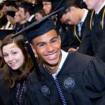 Black male and white female smiling at the camera at graduation