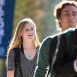 2 male and 1 female student walking on campus