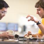 2 male students working together on a project in a lab