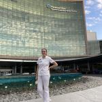 Audrey Smallman standing in her nursing uniform in front of a Cleveland Clinic building