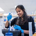 Female student working with pipettes in a lab