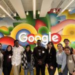 a group of students standing in front of a Google sign 