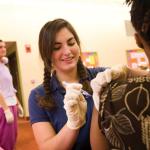 Nursing student giving a shot to someone.