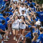 New students running through a tunnel of current students