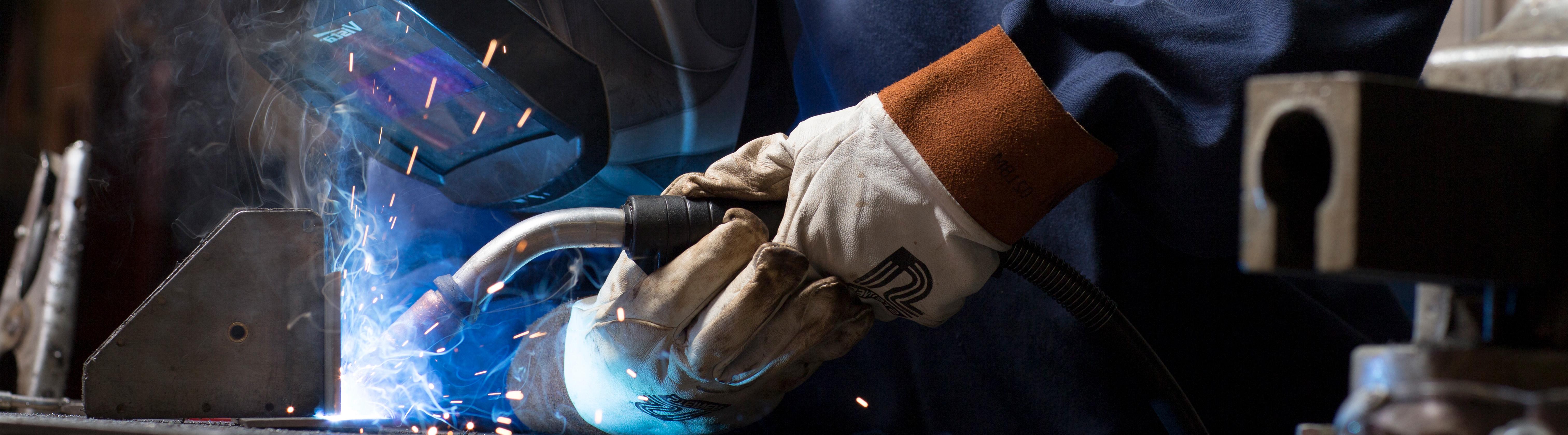 a student welding in the mechanic shop