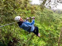 Student ziplining through a rainforest while abroad
