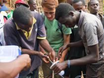 Student and local community members work on a lightbulb in Botswana