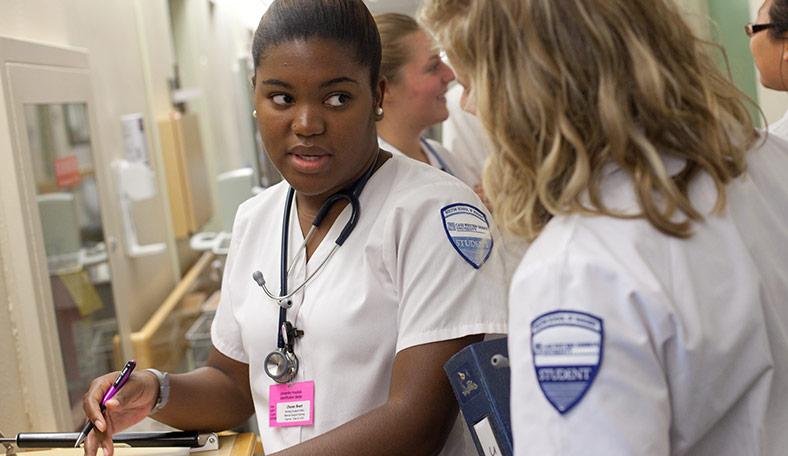 Two student nurses talking while on their shift