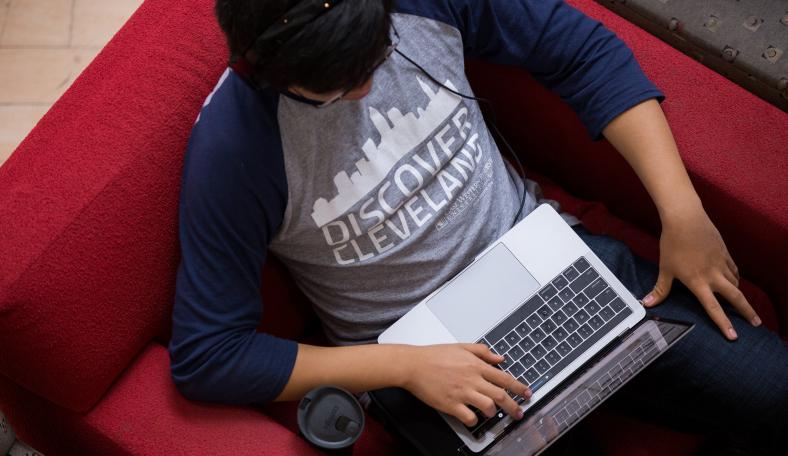 Case Western Reserve University student views computer from chair
