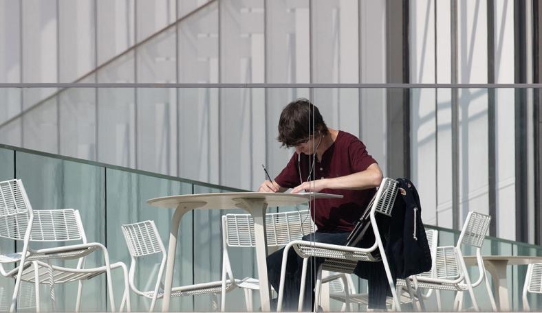 Student studying on a balcony