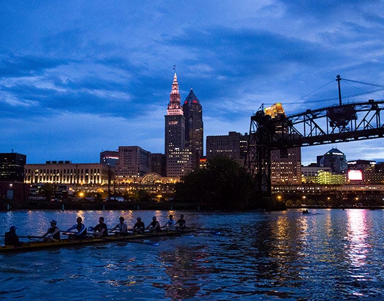 CWRU team rowing at night by downtown Cleveland