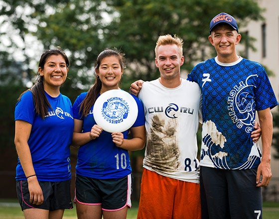 Ultimate Frisbee club posing with a frisbee after practice