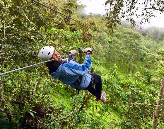 Student ziplining through a rainforest while abroad